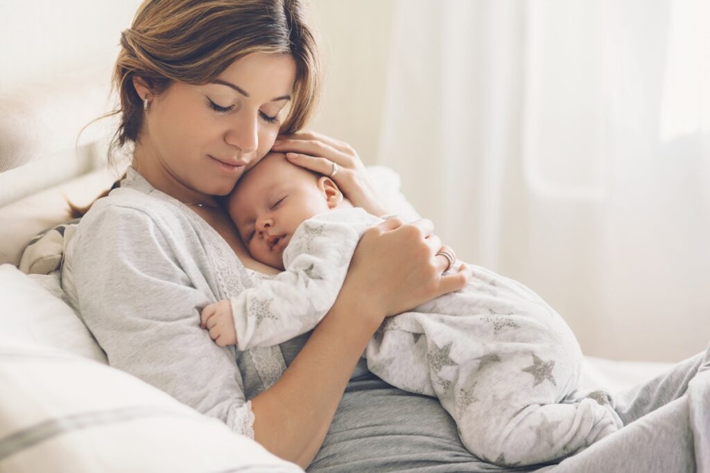 Loving mom carying of her newborn baby at home