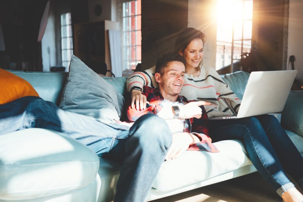 Casal assistindo filme em computador no sofá