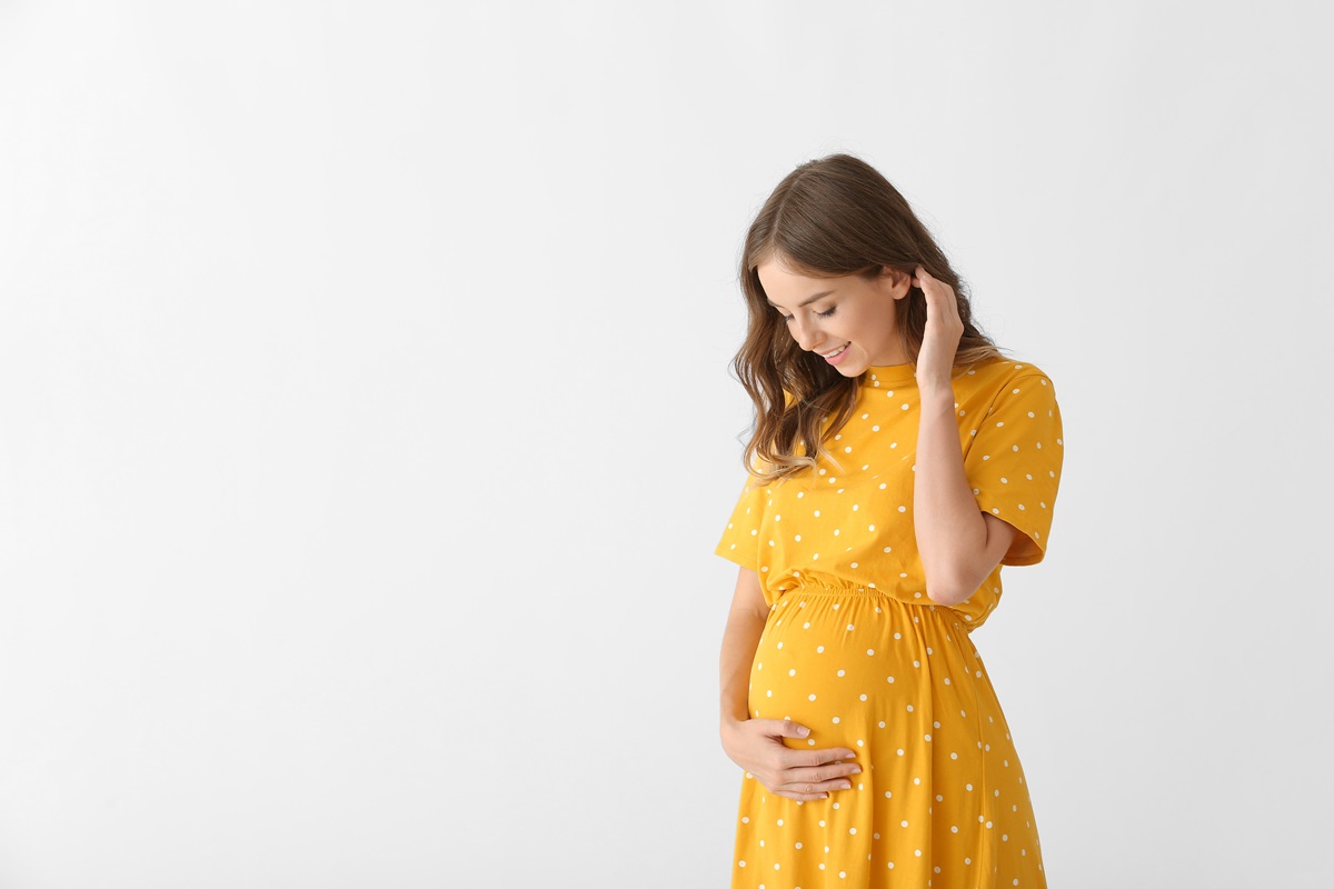 Mulher grávida sorrindo; Como Solicitar Auxílio-Maternidade