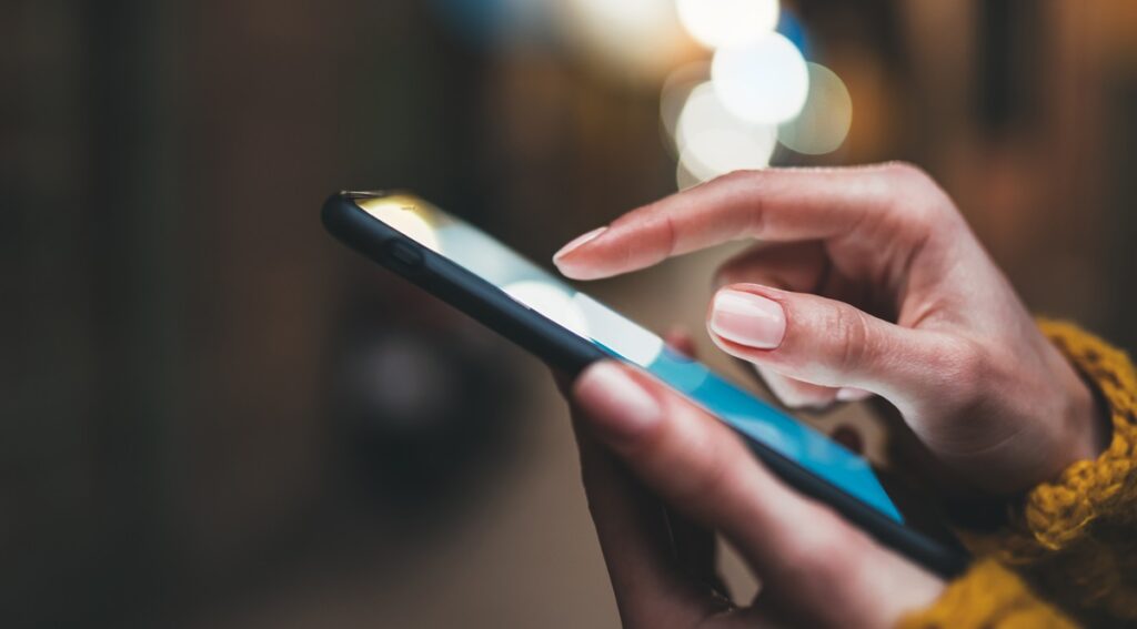 point finger on screen phone closeup, person texting text message