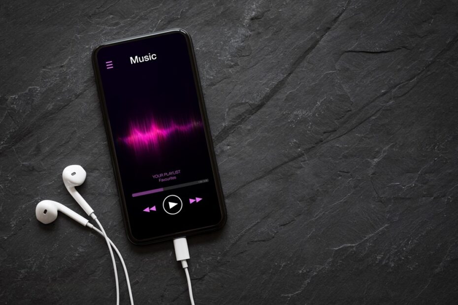 Celular e fones de ouvido em cima da mesa com app de música