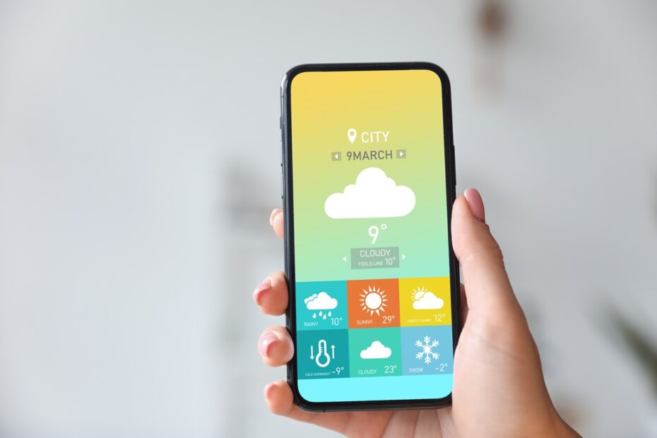 Mão segurando celular com app de previsão do tempo