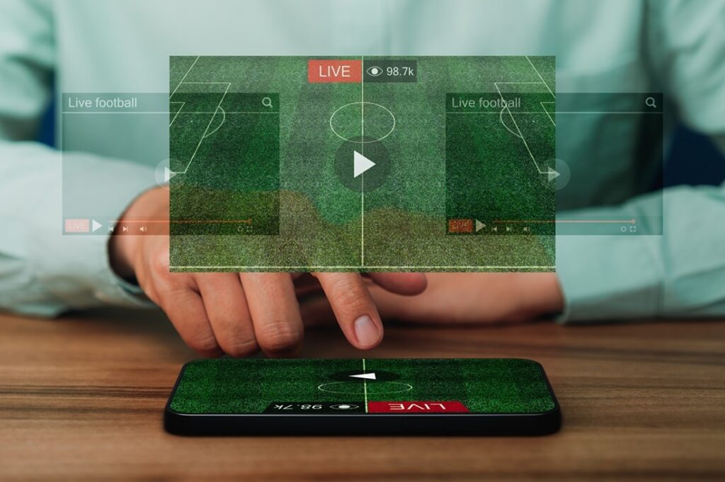 Man using a smartphone or mobile phone for watching live football streaming online on virtual screen